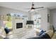 Inviting living room featuring a modern ceiling fan, fireplace, and sliding glass doors leading to the pool at 10250 Locker Dr, Spring Hill, FL 34608
