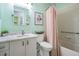 Clean bathroom featuring a vanity with white cabinets, shower-tub combo and neutral decor at 1033 Ashbourne Cir, Trinity, FL 34655