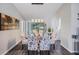 Elegant dining room with stylish chairs, modern lighting, and sliding glass doors to the backyard at 1033 Ashbourne Cir, Trinity, FL 34655