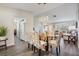 Open-concept dining room adjacent to kitchen and living room, featuring modern lighting and hardwood floors at 1033 Ashbourne Cir, Trinity, FL 34655