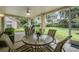 Enclosed lanai with ceiling fan, and patio furniture with lovely views of the green backyard at 1033 Ashbourne Cir, Trinity, FL 34655