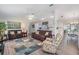 Open-concept living room with cozy seating, area rug, and dining area at 1033 Ashbourne Cir, Trinity, FL 34655