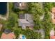 Aerial view showing the home's layout, roof, pool and the lush, mature landscaping surrounding the property at 10531 Pontofino Cir, Trinity, FL 34655