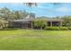 Expansive backyard featuring a screened pool, covered patio, lush landscaping, and mature trees at 10531 Pontofino Cir, Trinity, FL 34655