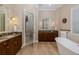Elegant bathroom featuring double vanities, soaking tub, and tiled floors at 10531 Pontofino Cir, Trinity, FL 34655