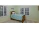 Cozy bedroom featuring a twin bed, two windows with plantation shutters, and light green walls at 10531 Pontofino Cir, Trinity, FL 34655