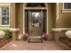 Close-up of the front door, accentuated with sidelights and potted flowers at 10531 Pontofino Cir, Trinity, FL 34655