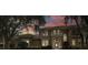 Elegant two-story home boasts a tile roof, arched entryway, and a charming second-story balcony, all set against a colorful sunset at 10531 Pontofino Cir, Trinity, FL 34655