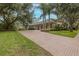 Stunning home exterior featuring a long driveway, three-car garage, and manicured landscaping at 10531 Pontofino Cir, Trinity, FL 34655