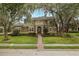 Inviting two-story home with lush landscaping, brick walkway, and elegant architectural details at 10531 Pontofino Cir, Trinity, FL 34655