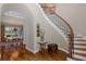 Welcoming foyer showcasing hardwood floors, a curved staircase, and views into the dining area at 10531 Pontofino Cir, Trinity, FL 34655