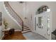 Grand foyer with a curved staircase, hardwood floors, and an ornate front door at 10531 Pontofino Cir, Trinity, FL 34655