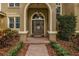Elegant front door with decorative glass and sidelights, framed by lush landscaping and a brick walkway at 10531 Pontofino Cir, Trinity, FL 34655