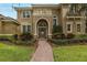 Charming front entrance features an arched doorway, decorative details, and manicured landscaping at 10531 Pontofino Cir, Trinity, FL 34655
