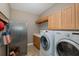 Functional laundry room with washer, dryer, sink, and storage cabinets at 10531 Pontofino Cir, Trinity, FL 34655