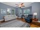 Cozy living room featuring hardwood floors, a ceiling fan, and ample natural light from the windows at 10531 Pontofino Cir, Trinity, FL 34655