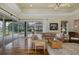 Bright living room with wood floors, access to the outdoor pool and comfortable seating arrangements at 10531 Pontofino Cir, Trinity, FL 34655