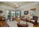 Inviting living room with a fan, neutral tones, wood floors, and sliding glass doors leading to the patio at 10531 Pontofino Cir, Trinity, FL 34655