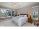 Main bedroom featuring a tray ceiling, ceiling fan, and large windows overlooking the pool at 10531 Pontofino Cir, Trinity, FL 34655