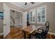 Bright office space with hardwood floors, a large desk, and plantation shutters for natural light at 10531 Pontofino Cir, Trinity, FL 34655