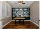 Bright office with a custom-built bookcase, wood floors, and plantation shutters at 10531 Pontofino Cir, Trinity, FL 34655