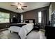 Main bedroom features dark walls, neutral bedding, and a dresser with bright natural light at 10670 43Rd N St # 204, Clearwater, FL 33762
