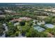 Overhead view of community clubhouse featuring a pool, tennis courts, parking area and mature landscaping at 11404 Inman Ct, Spring Hill, FL 34609
