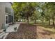 Backyard features a tiled patio area and a lush, wooded landscape at 11404 Inman Ct, Spring Hill, FL 34609