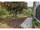 Tranquil backyard with mature trees and a tiled patio at 11404 Inman Ct, Spring Hill, FL 34609