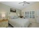 Bright bedroom with a comfortable bed, ceiling fan, and plantation shutters at 11404 Inman Ct, Spring Hill, FL 34609