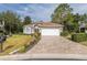 Charming single-story home featuring a well-manicured lawn and a brick paver driveway at 11404 Inman Ct, Spring Hill, FL 34609