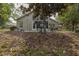 Rear exterior view of home with mature tree, potted plants and patio at 11404 Inman Ct, Spring Hill, FL 34609
