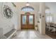 Inviting foyer featuring tile floors, a decorative wreath, and a bench, leading to a dining room at 11404 Inman Ct, Spring Hill, FL 34609