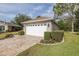Spacious two-car garage with brick paver driveway and manicured hedges at 11404 Inman Ct, Spring Hill, FL 34609