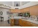 Well-lit kitchen showcasing white countertops, a stainless steel dishwasher, and wood cabinets at 11404 Inman Ct, Spring Hill, FL 34609