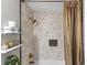 Clean bathroom featuring a tiled shower, gold fixtures, and open shelving at 1142 Wolford Dr, Trinity, FL 34655