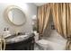 Bathroom featuring a unique vanity with a marble countertop, round mirror, and decorative gold shower curtain at 1142 Wolford Dr, Trinity, FL 34655