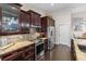 Well-equipped kitchen with dark wood cabinets, stainless steel appliances, and granite countertops at 1142 Wolford Dr, Trinity, FL 34655