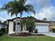 Attractive single-story home with palm trees, a two-car garage, and a well-kept lawn at 11520 Lounds Ct, New Port Richey, FL 34654