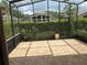 Relaxing screened patio with brick pavers and view of landscaped backyard and hedges for outdoor enjoyment at 11520 Lounds Ct, New Port Richey, FL 34654