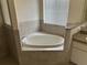 Bright bathroom with a large soaking tub and tiled surround, perfect for relaxation and comfort at 11520 Lounds Ct, New Port Richey, FL 34654