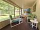 Enclosed sunroom with cushioned furniture and an array of large windows overlooking the backyard at 11733 Bayonet Ln, New Port Richey, FL 34654