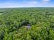 A sprawling property with mature trees hiding a home, patios, and surrounding structures at 12085 Stringer Rd, Brooksville, FL 34601