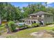 A beautiful home featuring an outdoor pool with a deck, luscious landscaping, and plenty of shade trees at 12085 Stringer Rd, Brooksville, FL 34601