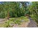 Lush backyard featuring vibrant greenery, mature trees and custom landscaping at 12085 Stringer Rd, Brooksville, FL 34601