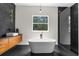 A modern bathroom with a sleek tub, an enclosed shower, floating vanity, modern fixtures, and stylish decor at 12085 Stringer Rd, Brooksville, FL 34601