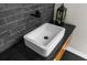 Modern bathroom featuring a sleek, rectangular sink and black fixtures against a stylish black tile backsplash at 12085 Stringer Rd, Brooksville, FL 34601