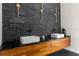 Modern bathroom featuring a black accent wall, double sinks, and wood drawers at 12085 Stringer Rd, Brooksville, FL 34601