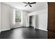 Bedroom featuring dark floors, closet space, ceiling fan, and a large bright window at 12085 Stringer Rd, Brooksville, FL 34601