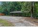 Spacious carport area with ample parking space and a metal roof, surrounded by mature trees at 12085 Stringer Rd, Brooksville, FL 34601